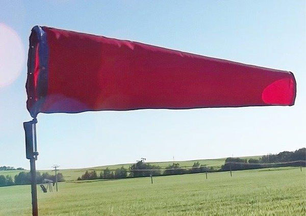 Red windsock in field
