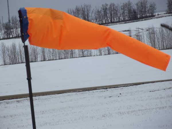 Orange windsock on snowy background